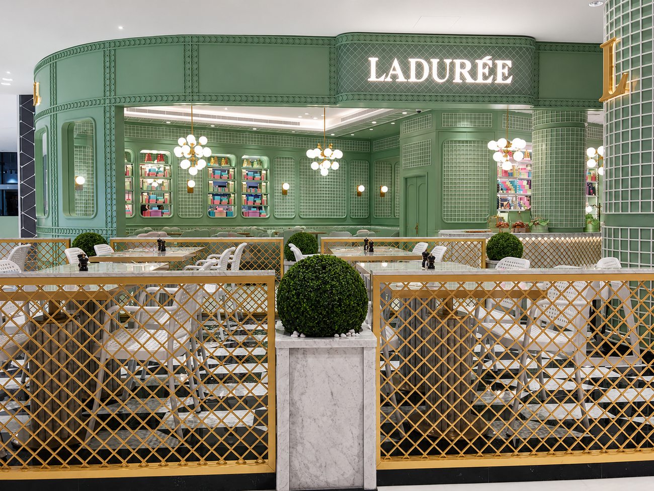 Laduree terrace seating area with white chairs and gold lattice, The Dubai Mall
