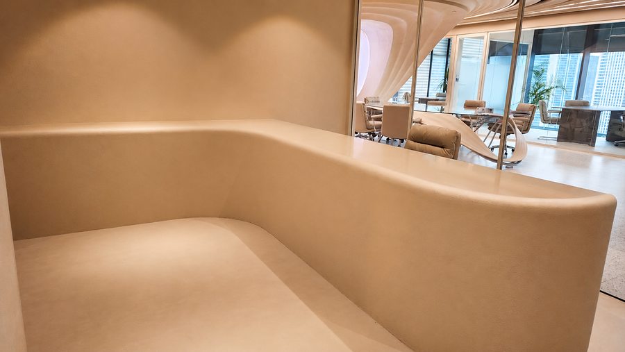 RIN Foundation bespoke curved reception bench in micro-cement, fitted by Davies Group UAE